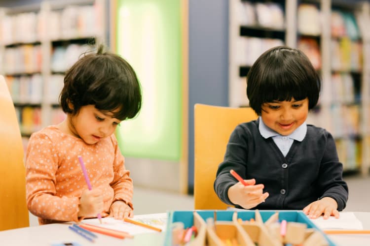 Two children colouring in at their local library.