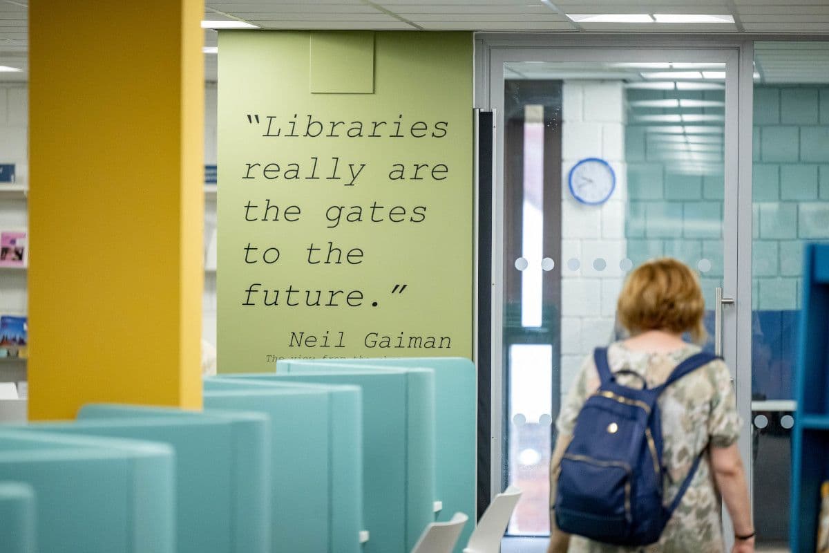 The interior of a library displaying a quote from author Neil Gaiman: "Libraries really are the gates to the future".