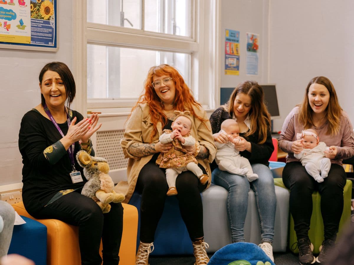 A group of parents and library staff enjoying rhymetime with infants.
